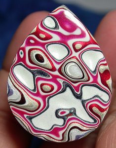 red black and white fordite cabochon