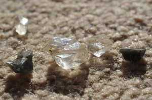 Lake County diamonds and rainbow obsidian lined up on a carpet