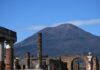 Famous Volcanoes in Italy: Fiery Trio Mt Vesuvius rises up above the ruins of the Firum in Pompeii.