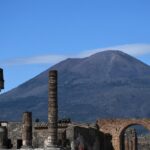 Famous Volcanoes in Italy: Fiery Trio Mt Vesuvius rises up above the ruins of the Firum in Pompeii.