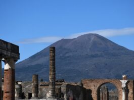 Famous Volcanoes in Italy: Fiery Trio Mt Vesuvius rises up above the ruins of the Firum in Pompeii.