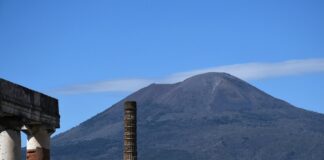 Famous Volcanoes in Italy: Fiery Trio Mt Vesuvius rises up above the ruins of the Firum in Pompeii.