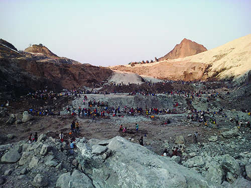 Unlicensed artisanal miners search a Hpakan mine dump