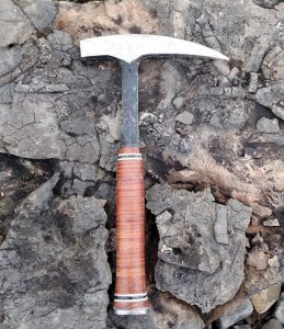 fossil hunting hammer laying on exposed rock