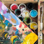 What Minerals Make Paint Colors? Paints of different colors and dirty brushes on an easel.