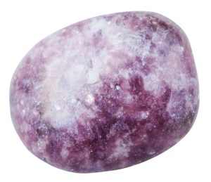 macro shooting of natural mineral stone - tumbled lepidolite gemstone isolated on white background