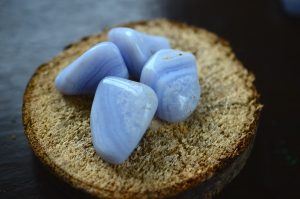 blue lace agate tumbled stones on wood round