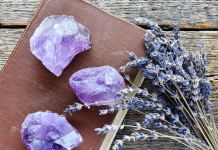 amethyst stones on a leather book with lavendar branch