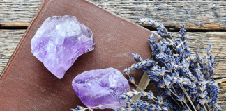 amethyst stones on a leather book with lavendar branch