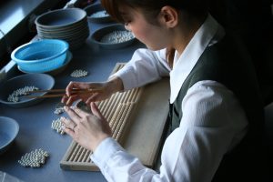 A man is checking some pearls