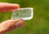 Iceland Spar: Optical Calcite Iceland spar, a colorless and transparent mineral crystal held in a hand