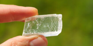 Iceland spar, a colorless and transparent mineral crystal held in a hand