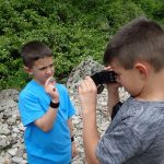 kids rock collecting in a rocky area
