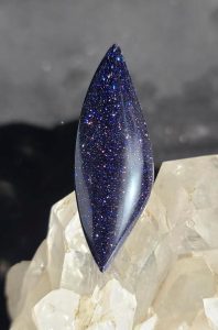 blue goldstone cabbed into an elongated teardrop shape