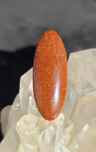 orange goldstone cabbed into a long oval shape