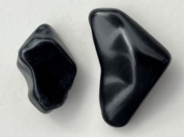Jet Stone: History and Identification a piece of jet stone and a piece of obsidian for comparison