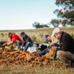 people digging for microfossils in a field