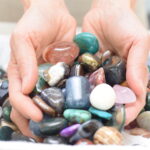 hands holding polished rocks