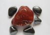 a large red hematite stone surrounded by gray magnetic hematite stones