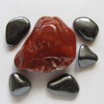 Hematite Stone: Rock Science a large red hematite stone surrounded by gray magnetic hematite stones