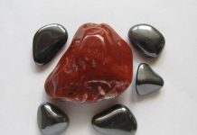 a large red hematite stone surrounded by gray magnetic hematite stones