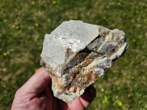 amazonite being held by hand in the sunlight