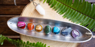seven chakra stones over wooden background, energy healing concept