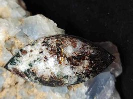 astrophyllite cabochon with mineral background