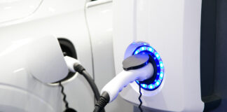 Electric car charging station. Close up of the power supply plugged into an electric car, using EV minerals, being charged