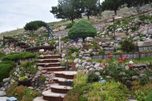 perennials  interspersed with the rock, while juniper shrubs creep across the lower backyard