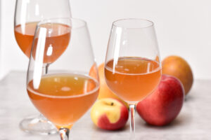 glasses of snow capped cider with apples next to them with the taste credited to Colorado terroir