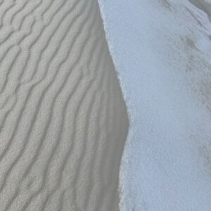 Contrast of gypsum white sand covered by snow at White Sands National Park.