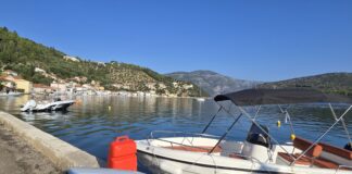 Ithaca, Greece: Monoliths and the Island of Odysseus The picturesque capital of Ithaca, Greece, and the main port of Vathy. In the background is the road leading high up to the Monoliths.
