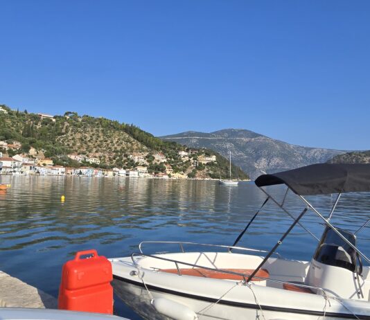 Ithaca, Greece: Monoliths and the Island of Odysseus The picturesque capital of Ithaca, Greece, and the main port of Vathy. In the background is the road leading high up to the Monoliths.