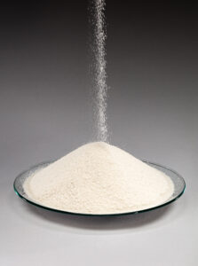 Gypsum sand accumulated and pouring into a bowl.