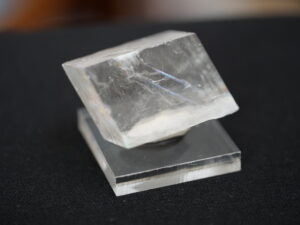 Calcite crystal with visible cleavage planes reflecting light.
