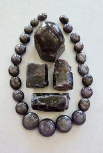 The beads and top specimen are plum-colored star sapphires from India, while the three perfect, glassy-looking blue-violet crystals are from Madagascar.