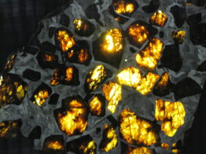 When pallasites are slabbed and backlighted, their olivine crystals glow with an otherworldly beauty.